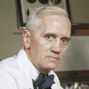 Alexander Fleming working in a lab holding a petri dish