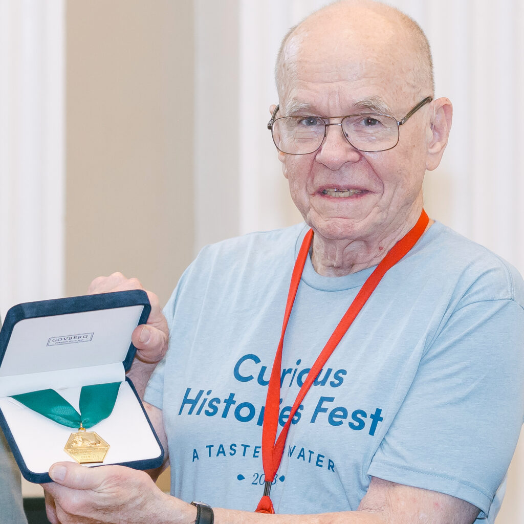 K. Barry Sharpless holding up his AIC Gold Medal