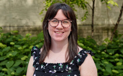 Caroline outdoors smiling with sleeveless floral top