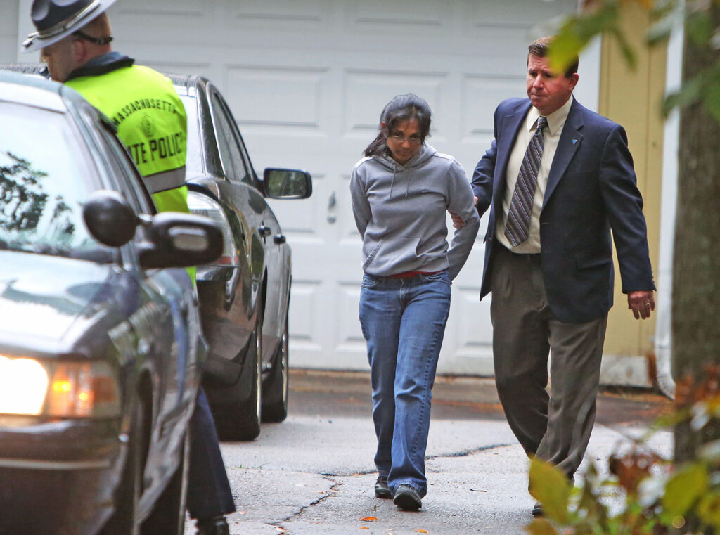 Photo of woman in handcuffs escorted by man