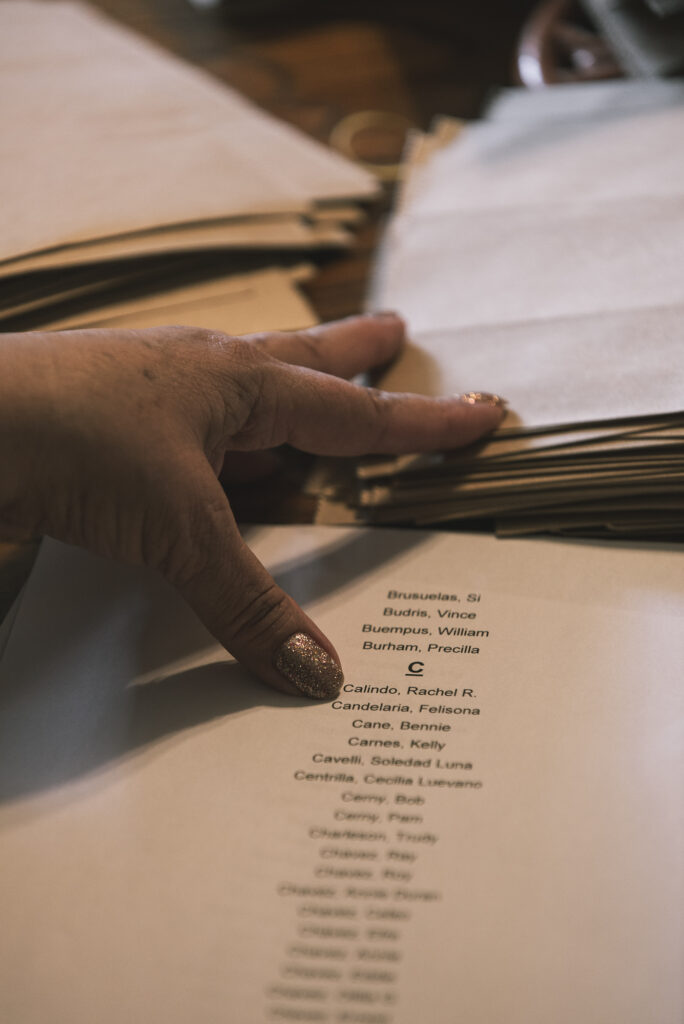 close up of a hand holding a long list of names