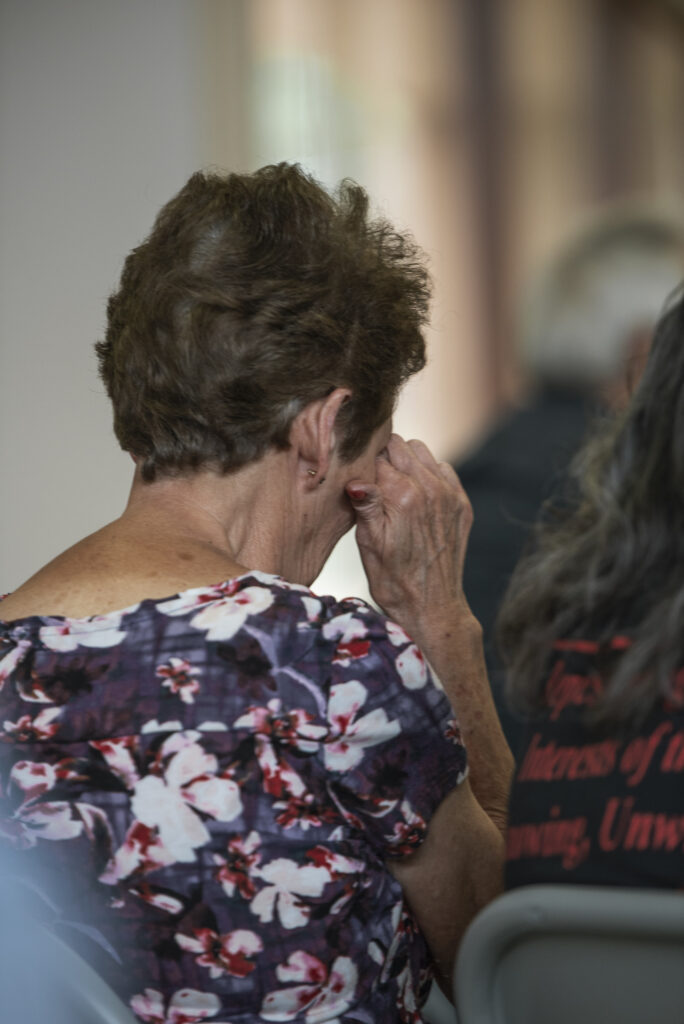 Close up from behind of a seated woman crying