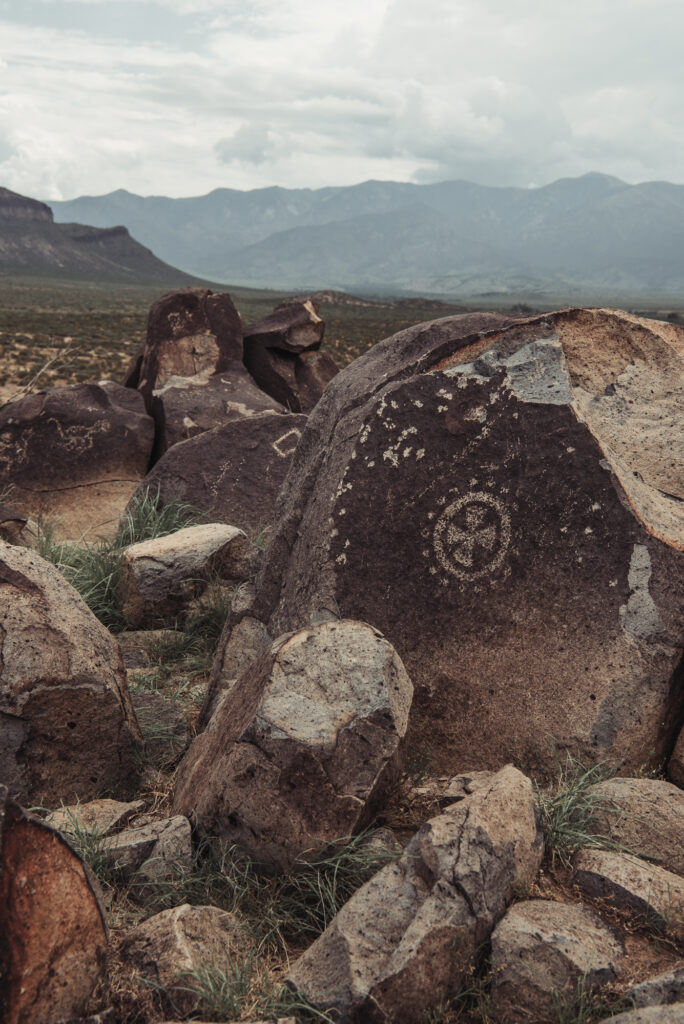 A group of dark rocks and boulders with white designs on them