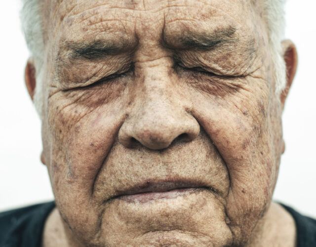 Close-up portrait of an older man with his eyes closed