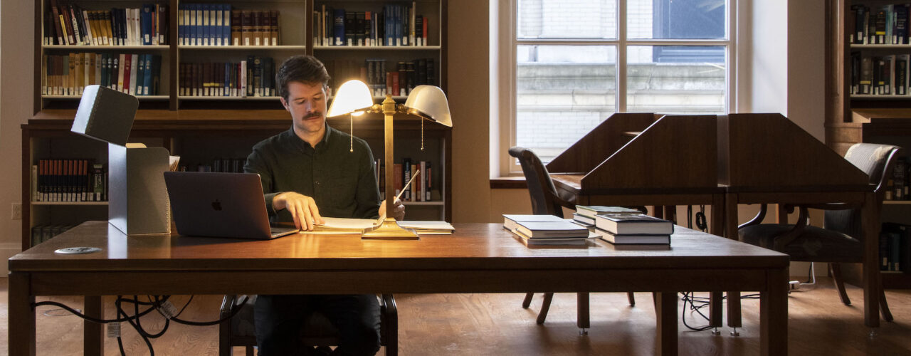 man doing research in a library