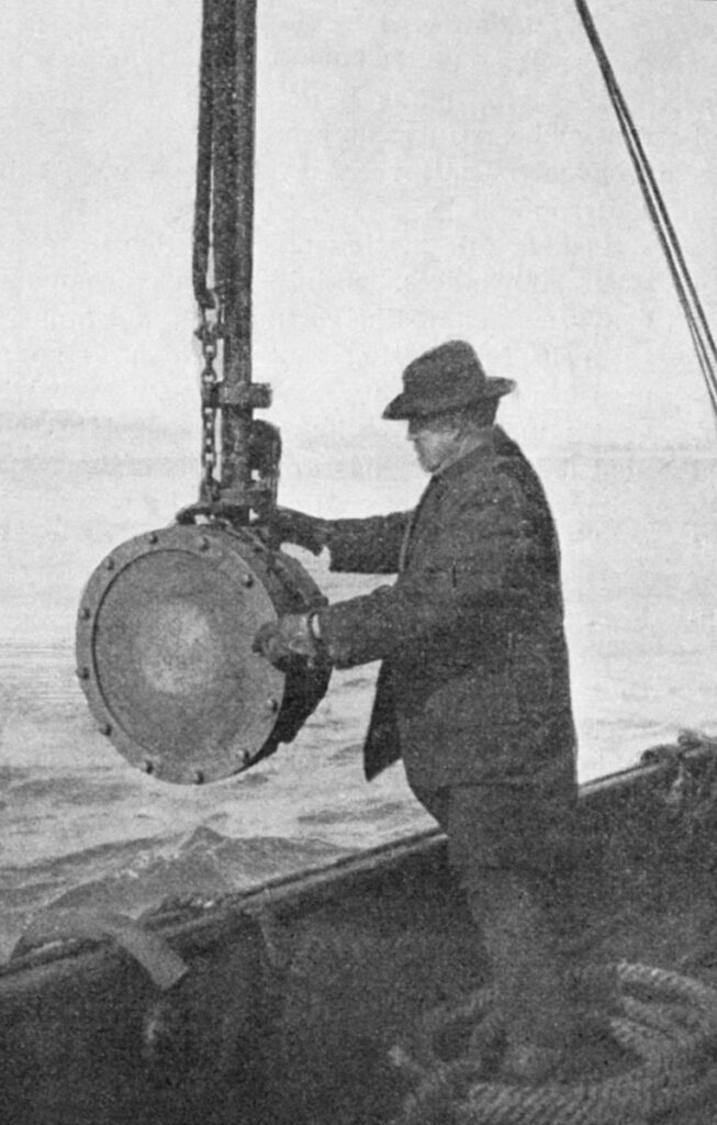 black and white photo of man with equipment on a rope