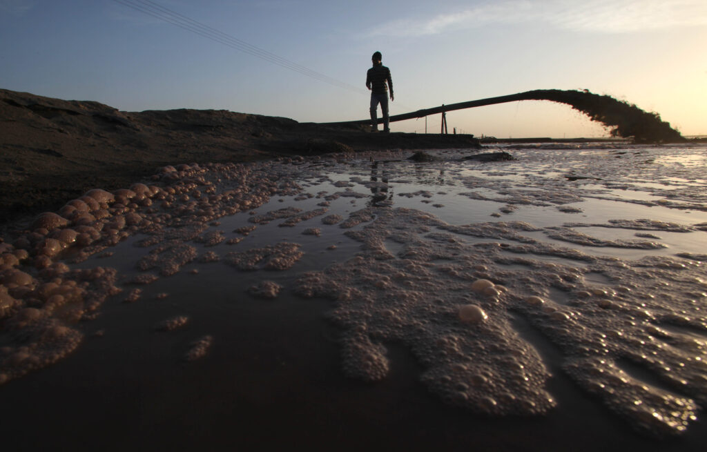 Silhouette of pipe spewing water