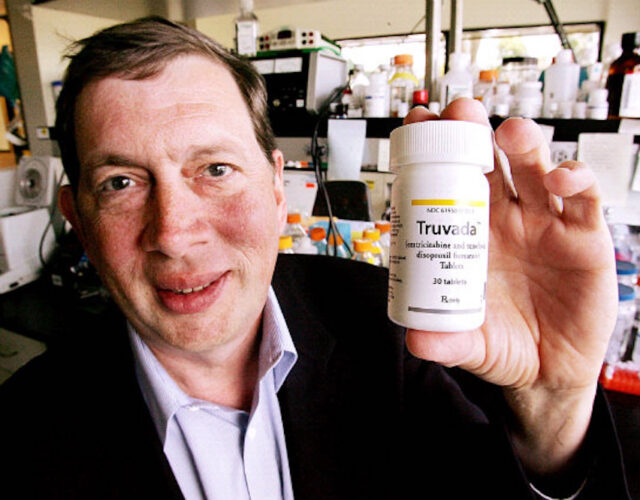 John C. Martin holds up a bottle of pills.