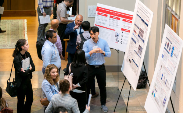 people conversing next to posters on easels