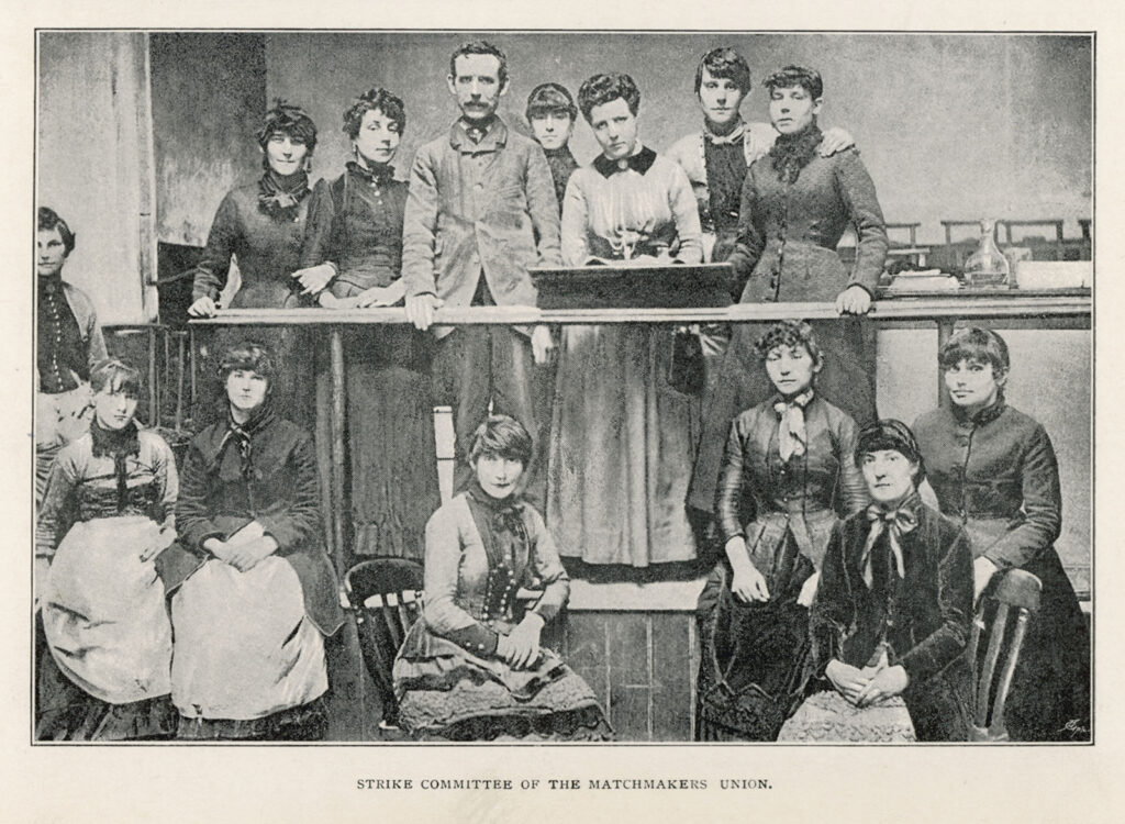 Black and white photo of Victorian men and women in an auditorium