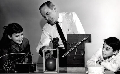 "Mr. Wizard" does an experiment with two children watching.