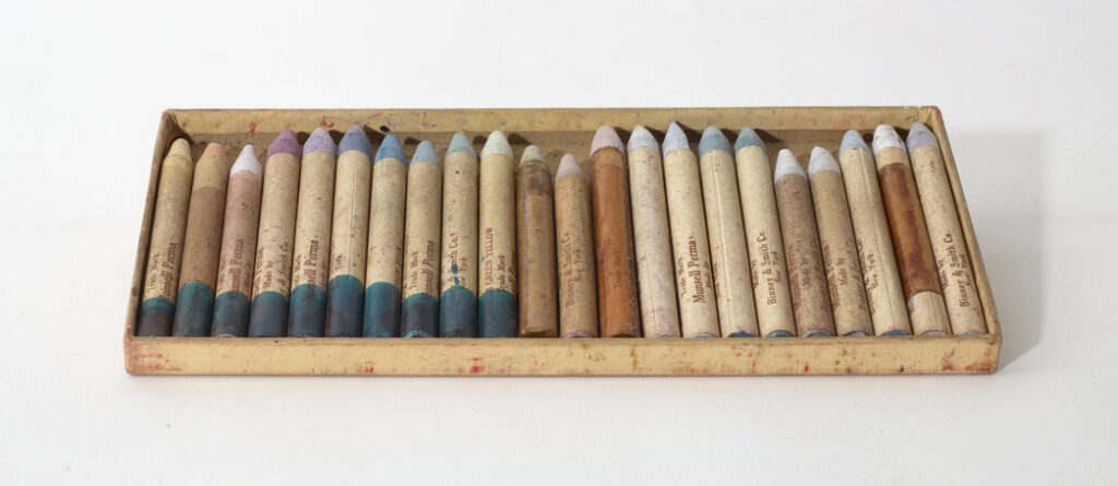 Interior of a box of 22 old, faded crayons