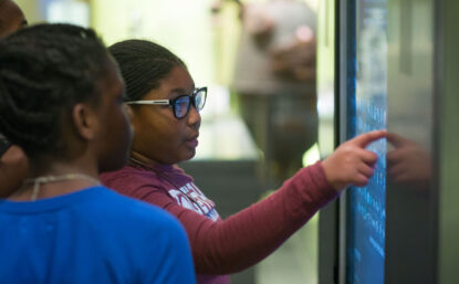 two children pointing at museum display