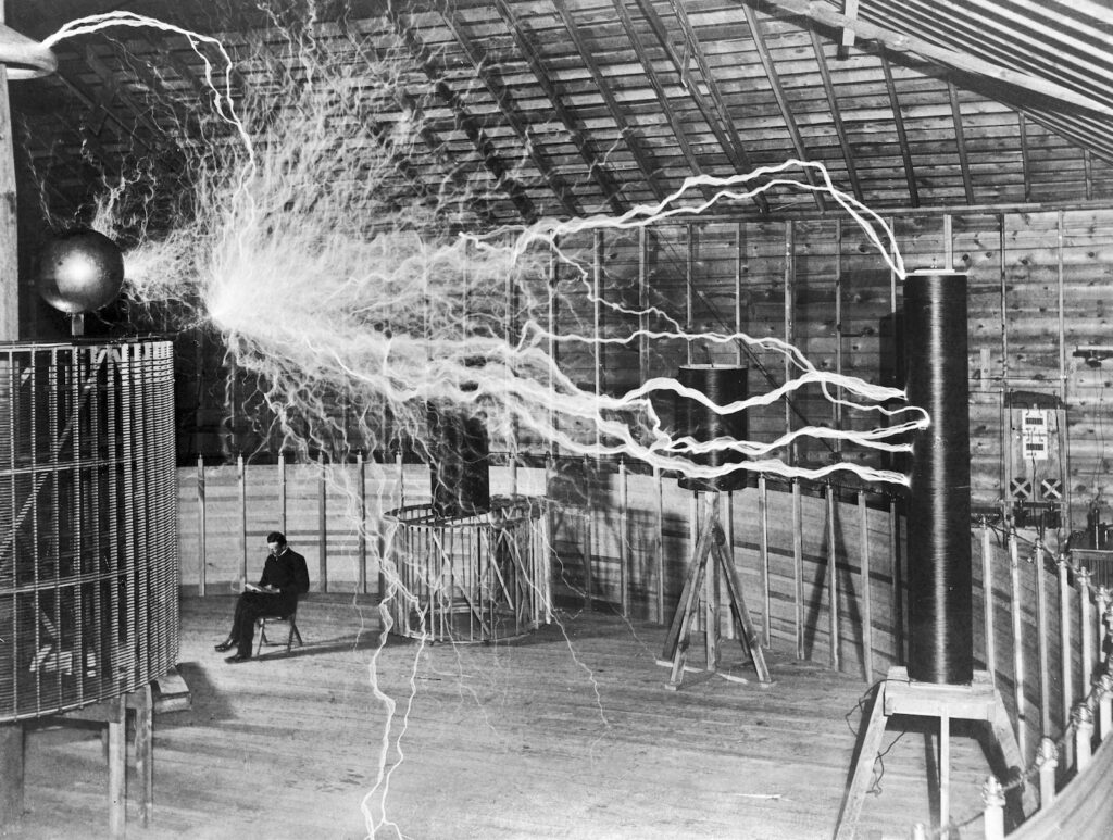 Black and white photo of seated man surrounded by lightening