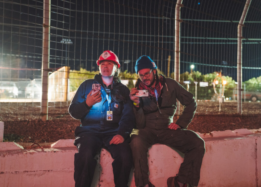 Portrait of a seated couple in protective equipment filming fireworks