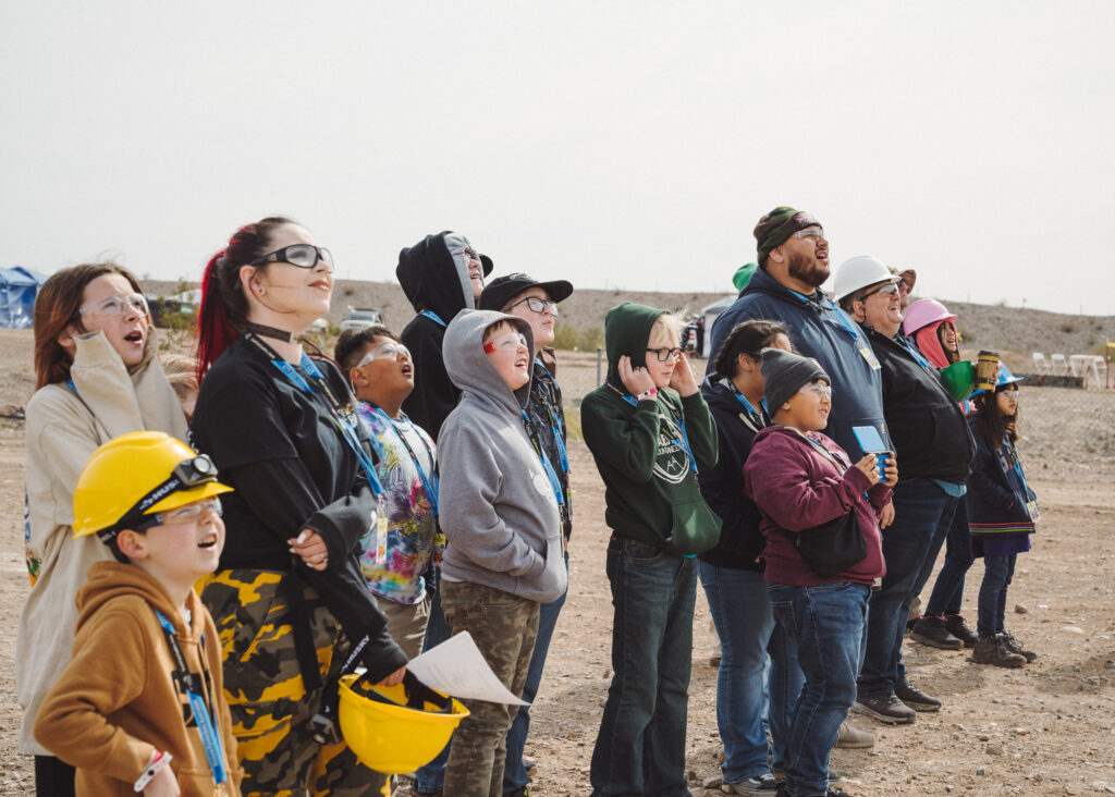 Families wearing safety equipment looking to sky