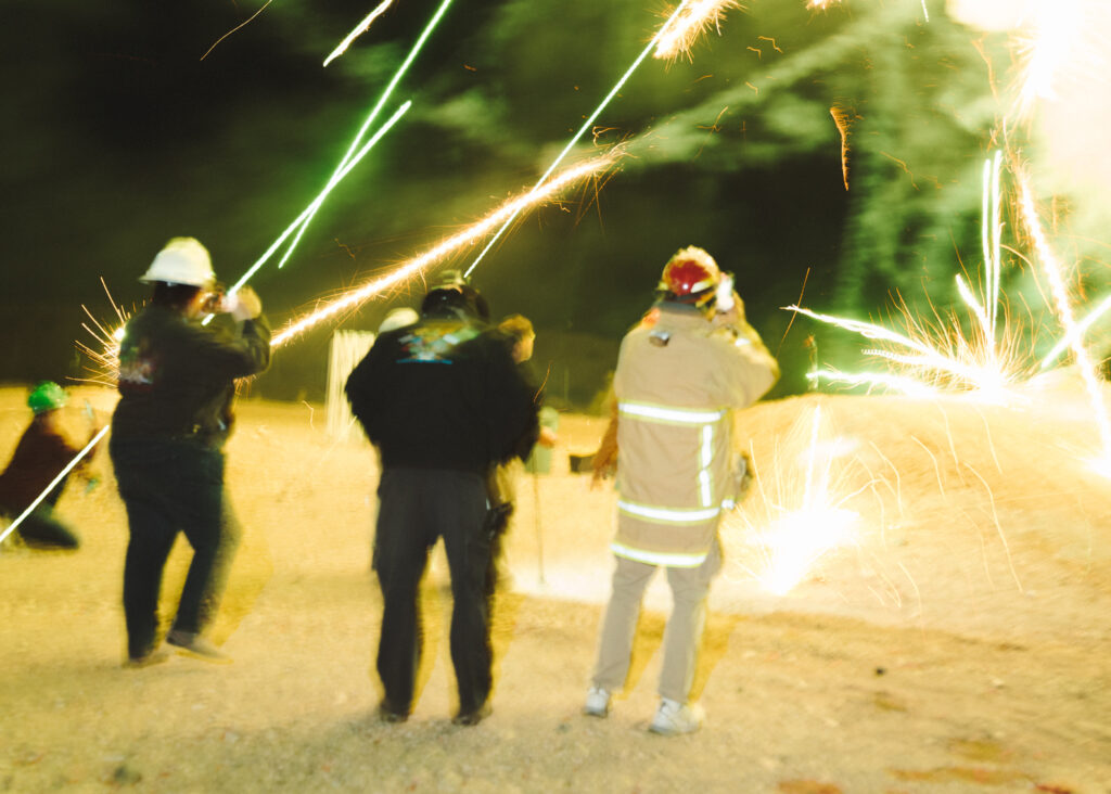 Blurry photo of the backs of people filming fireworks display