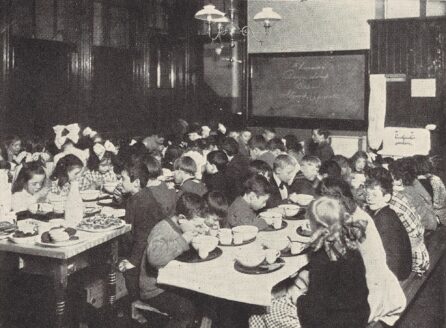 black and white photo of kids eating at tables