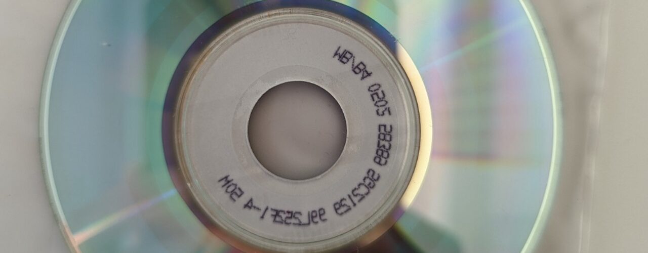 A shiny, reflective CD on top of a plastic sleeve