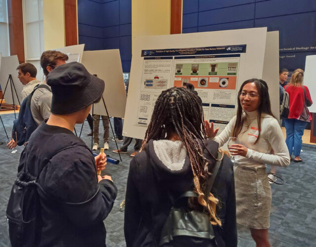 Scientist discussing her poster with visitors