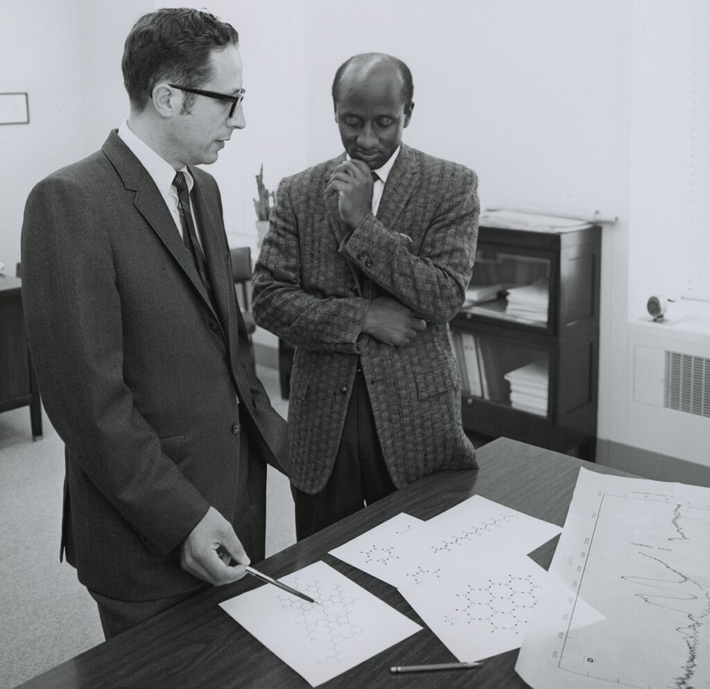 Photo of two men standing over a desk