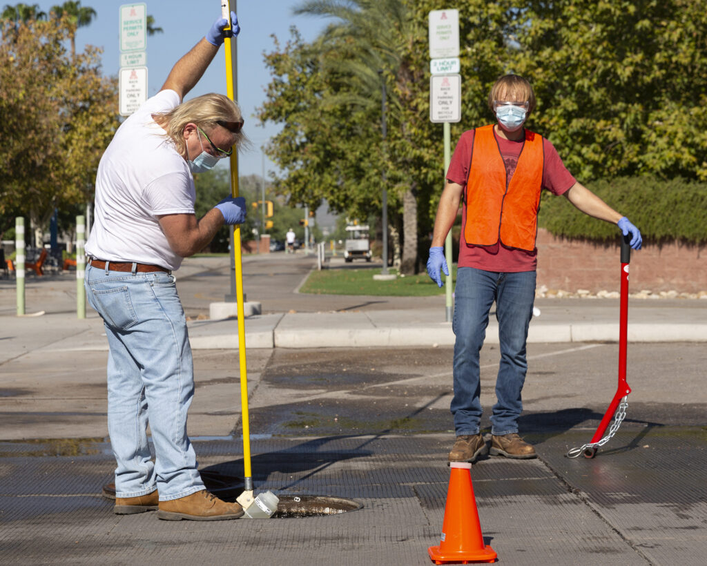 Two men working around a manhole