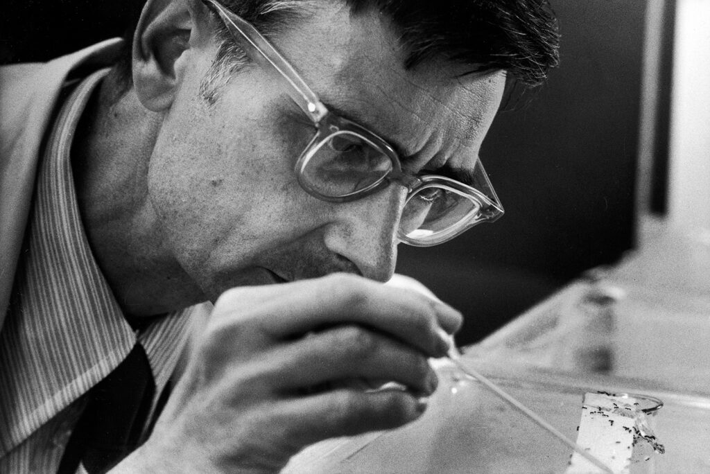 Black and white photo of a man working in a lab 