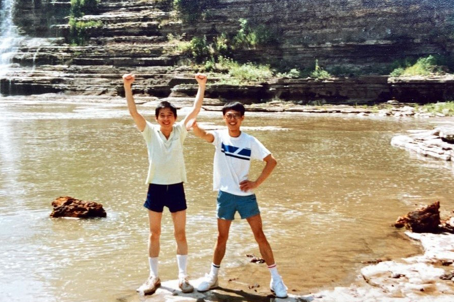 Two men standing by a waterfall