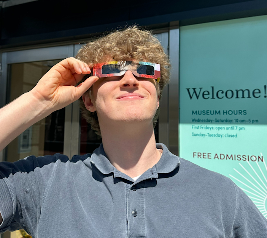 person looking at the sun with eclipse glasses on